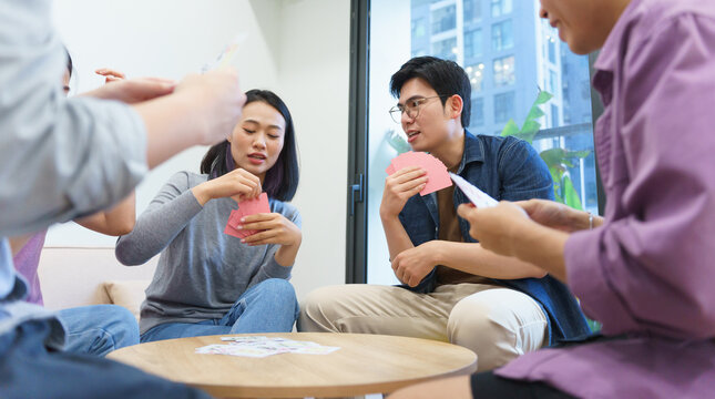 Group of friends enjoying card games indoors in a modern apartment during a relaxing evening