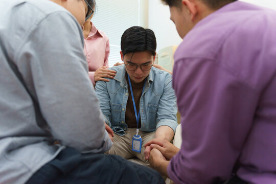 Group of friends offering emotional support during challenging times in a private setting