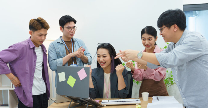 Excitement in a collaborative workspace as a team celebrates a project milestone in a modern office setting