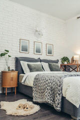 Stylish interior of bedroom with big comfortable grey bed