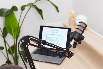 Podcast recording setup featuring a microphone and laptop in a modern office environment for...