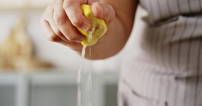 Hand squeezing lemon close up view