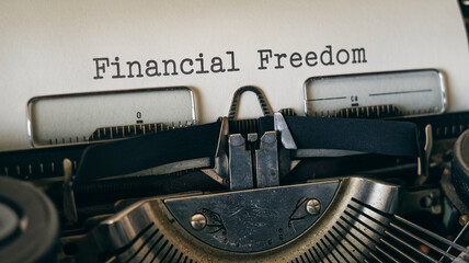 Close-up of vintage typewriter with "Financial Freedom" typed, showcasing a concept of achieving financial stability and independence through effort and planning