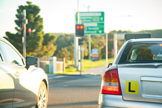 L plate car in peak hour traffic driving on road in the afternoon