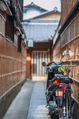 京都の小路に置かれているスクーターと自転車