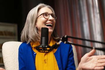 Senior radio host laughing during a live podcast recording