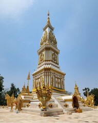 Naklejka premium Stunning Golden Stupa in a Serene Temple Setting Under Clear Sky