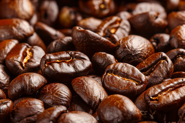 Fototapeta premium Close-up macro shot of dark roasted coffee beans, highlighting their rich brown color, glossy surface, and textured details.