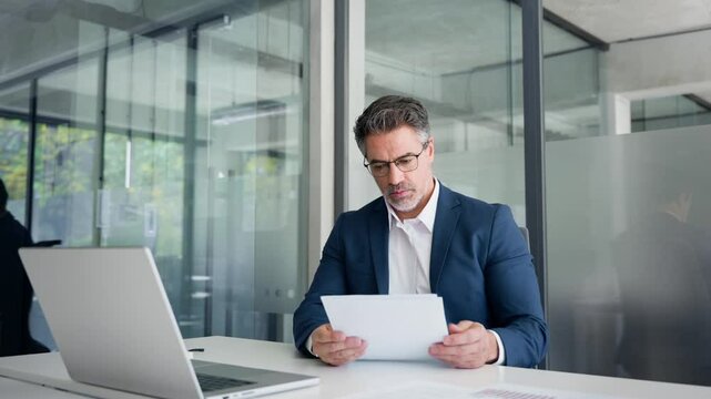 Busy financial specialist senior man working with finance sales document report and pc laptop computer in office. Mature executive businessman professional check analysing business, invest review 