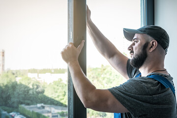 Master adjusting pvc windows handle with screwdriver. Installation of plastic windows repair and maintenance concept