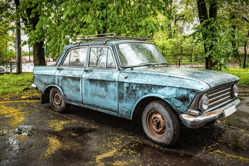 Old retro abandoned car under the rain
