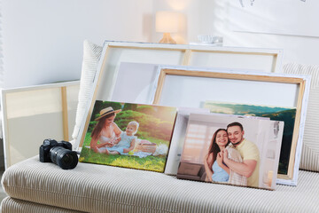 Canvas with different printed photos and camera on sofa indoors