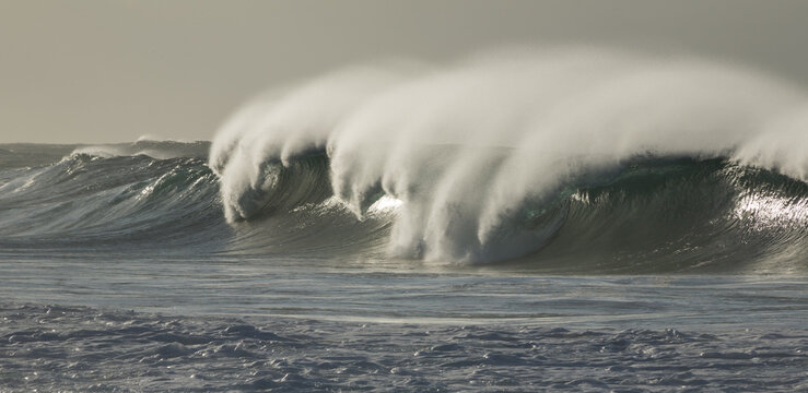 Large breaking wave with 'white horses' and blowback