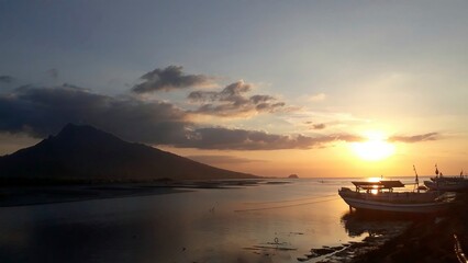 A beautiful view of the sun setting on a beach dock in Panarukan, Situbondo, East Java, Indonesia.