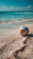 Obraz premium A bright soccer ball lies on a sandy beach by the sea under a blue sky.