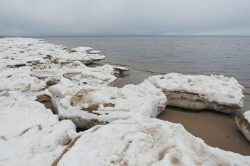 A beautiful snowy beach scene featuring a body of water in the background