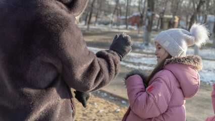 Grandparents with granddaughters playing in the park on a sunny winter day