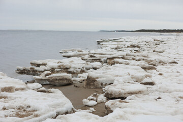 A beautiful snowy beach scene featuring a body of water in the background