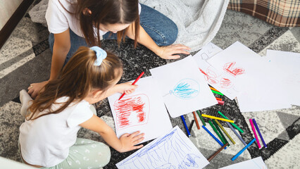 Mom fun painting with their daughter on the floor at home