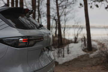 Obraz premium A white car is beautifully parked on a snowy road in the woods