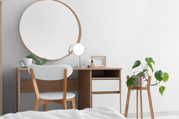 Dressing table with mirror and cosmetic products in bedroom