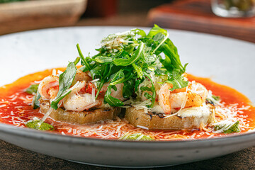 Portion of grilled aubergine appetizer with shimp and sauce