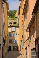 Cobblestone alley with traditional houses in pastel colours in the city of Lyon, France 