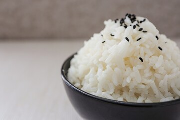 Close up Cooked white rice or steamed rice with black sesame on top  in a black  bowl