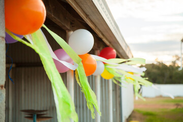 Birthday balloons tied along shed verandah