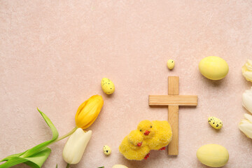 Wooden cross with painted eggs, chicks and tulip flowers on pink grunge background. Easter celebration