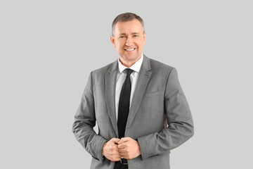 Portrait of mature businessman on grey background