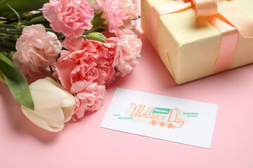 Bouquet of different beautiful flowers with greeting card and gift box on pink background, closeup....