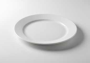 A simple white plate centered on a white surface with soft shadows creating a minimalist aesthetic look