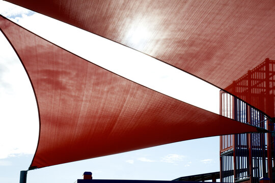Red shade sail above kid's playground