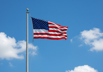 Obraz premium American Flag Waving in a Clear Blue Sky