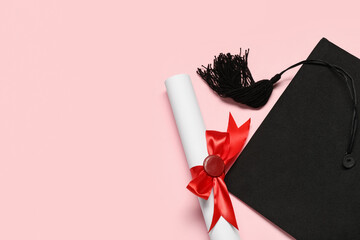Mortar board and diploma on pink background