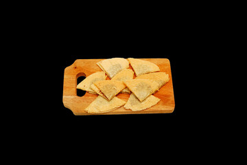 Kue Semprong or Asian egg roll. Indonesian traditional wafer snack made by clasping egg batter using an iron mold. Inside chocolate sauce, served on wooden plate and isolated on black background