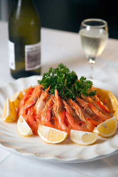 Fresh prawns arranged on a plate with lemon slices