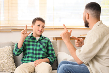 Mute father and son using sign language at home