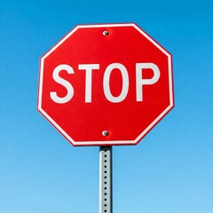 Obraz premium Bright red octagonal stop sign with bold white lettering against a clear blue sky