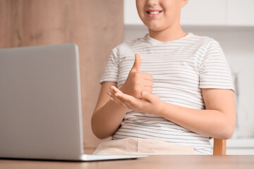 Mute boy using sign language during video call at home