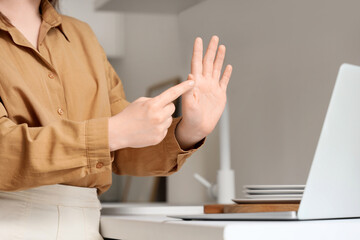 Young mute woman using sign language during video call at home