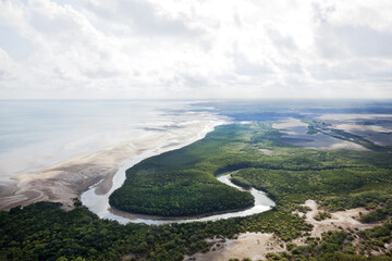 Aerial view of a curving river system running into the ocean