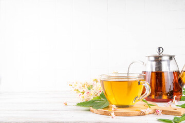 Organic natural chestnut leaves and flower tea. Hot alternative non-caffeine herbal drink, tasty healthy beverage, on white wooden background copy space
