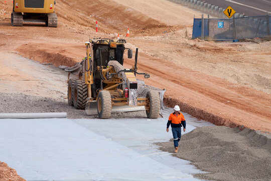 View of workers and heavy machinery on a road construction worksite