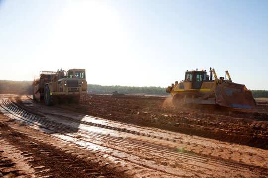 Heavy machinery flattening dirt to build a road