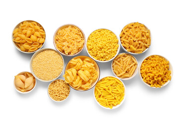 Bowls with different types of raw pasta on white background