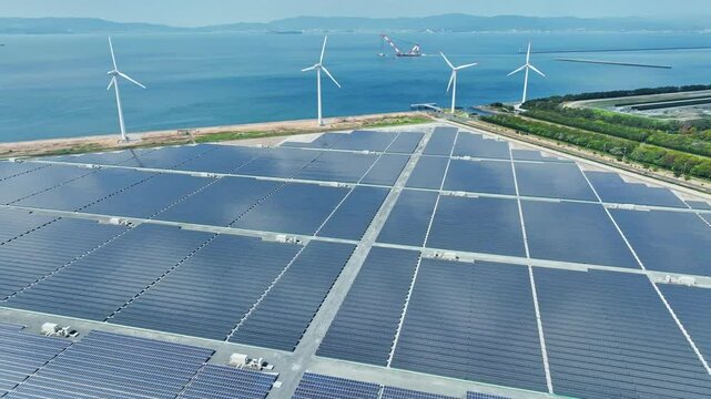 Aerial view of a hybrid power plant with wind turbines and solar panels