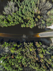 Lake District swallow hole flooded as a result of the mining damage Pomorzany mine in Olkusz,Poland. Aerial drone view of flooded road. Forest submerged in a lake. Sunken sandpit with clear water