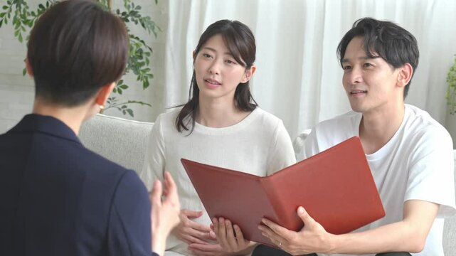 スーツを着た女性から話を聞く夫婦